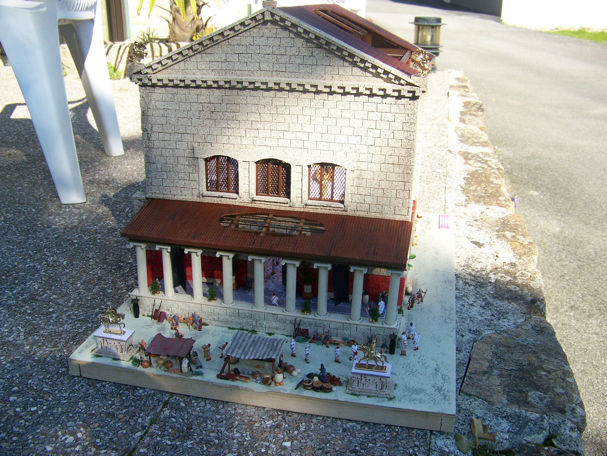 Maquette de la Curie Julia à Rome, avec ses colonnes et des personnages devant le bâtiment.